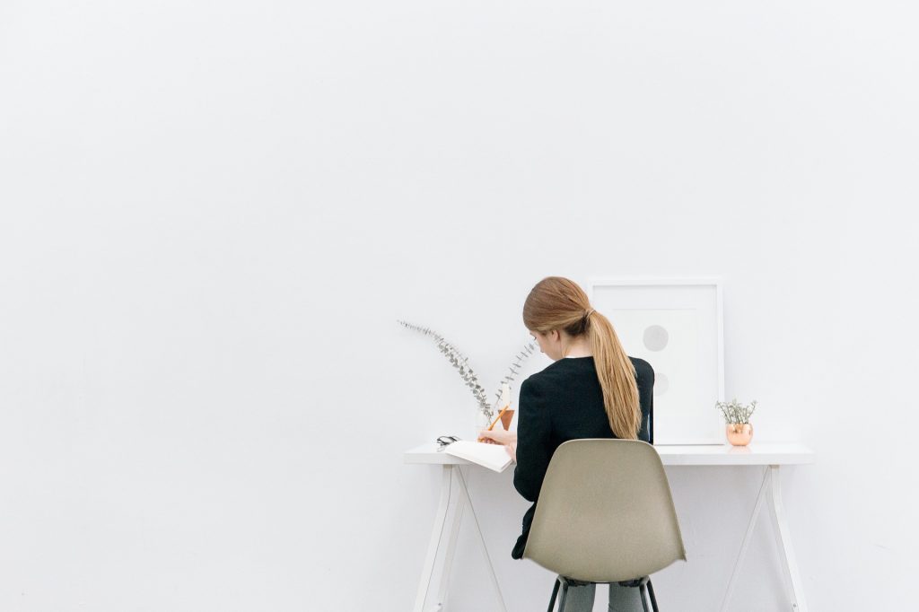 Une femme travaillant sur un petit bureau à la décoration minimaliste