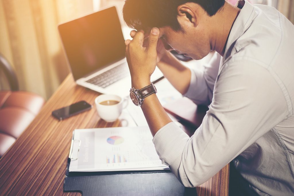 Un homme stressé par son travail assis devant un ordinateur