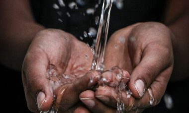 Mains recevant un filet d'eau